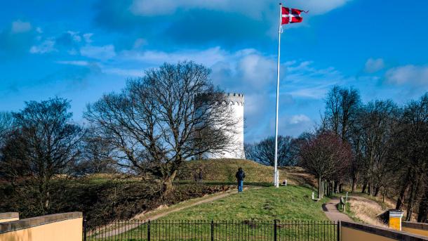 Walking along Fredericia Ramparts in sunshine – historic fortifications surrounded by greenery.