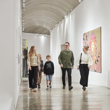 A family walks down the long corridor, which is full of intriguing artworks. They have experienced some of the many offers the museum has for families with children.