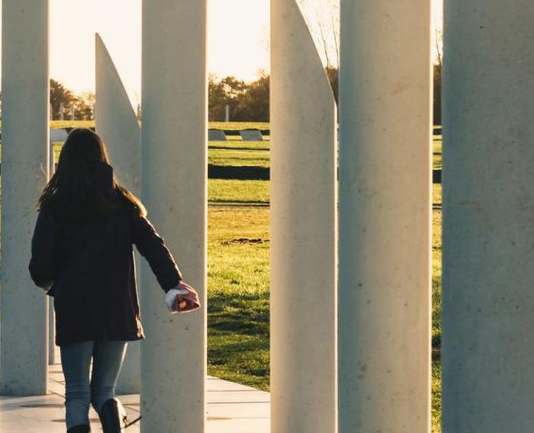 A person walks along the white concrete pillars illustrating where the palisade went around Gorm the Old's fortress